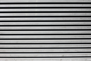 Corrugated metal sheet background. Grunge old grainy metal texture. Silver color industrial pattern. Garage construction gray striped wall. Horizontal metal stripes.