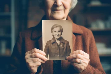 Foto op Canvas Senior Woman Holding a Vintage Photo of Her Younger Self - Memories and the Passage of Time in a Single Image © Ai Studio