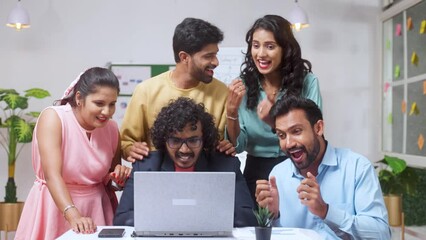 Group of team members celebrating success after seeing received mail from the laptop at office - concept of project deal, new business or client agreement and startup collaboration
