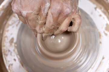 male hands making ceramic cup on pottery wheel, Close-up, top view - obrazy, fototapety, plakaty