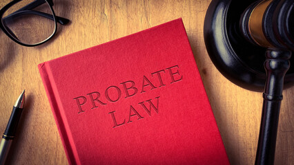 Probate law book with gavel, glasses and pen on wooden table. Law concept