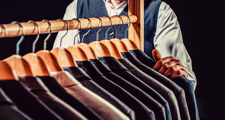 Tailor, tailoring. Stylish men's suit. Male suits hanging in a row. Men clothing, boutiques