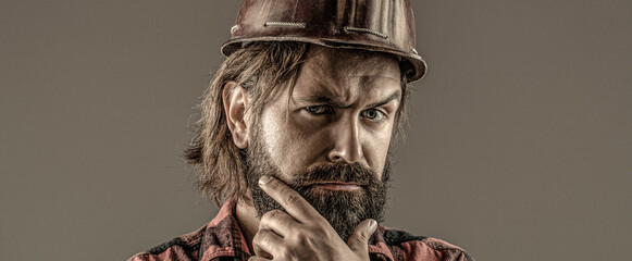 Building, industry - builder concept. Bearded man worker with beard in building helmet or hard hat....