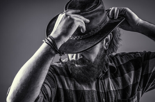 Cowboy hat. Portrait of young man wearing cowboy hat. Cowboys in hat. Handsome bearded macho. Black and white