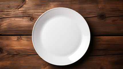White plate with cutlery at dark wooden table. Top view