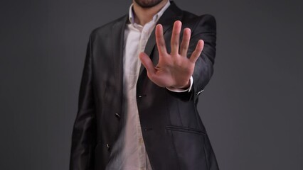 Capture a moment of decisive action with this impactful stock video featuring a man making a clear and assertive stop gesture. The scene opens with a dynamic close-up, focusing on the man's hand as he