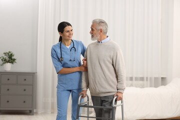 Smiling nurse talking with elderly patient in hospital