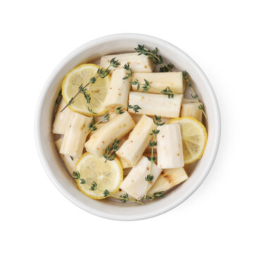 Dish with raw salsify roots, lemon and thyme isolated on white, top view
