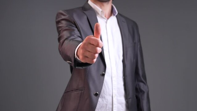 Radiate positivity and approval with this uplifting stock video capturing a man confidently giving a thumbs-up signal. The scene opens with a dynamic close-up, focusing on the man's hand as he extends