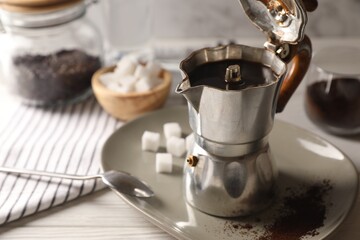 Brewed coffee in moka pot on white wooden table. Space for text