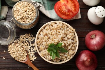 Delicious pearl barley served on wooden table, flat lay