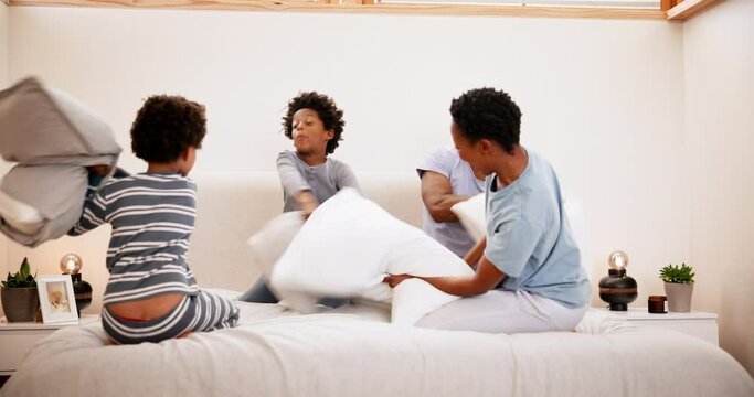 Family, pillow fight and playing on bed with happiness, communication and peace in the morning in home. Black people, parents or boy children with bonding, love and care in bedroom of house or energy