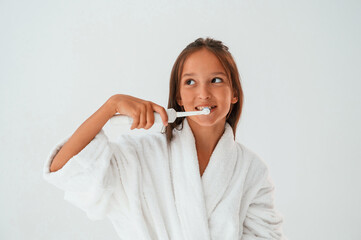 Using the toothbrush. Conception of beauty and self care. Young girl is in the studio