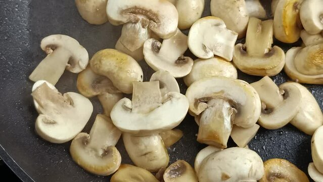 champignons de Paris cuisant dans une po&ecirc;le