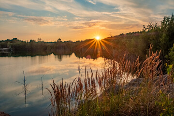 The image is a splendid showcase of nature's evening adieu, featuring the sun dipping low in the...