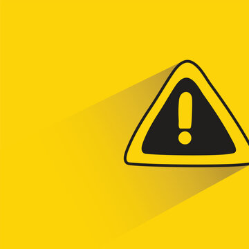 caution signage with shadow on yellow background