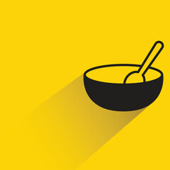 soup bowl and spoon with shadow on yellow background