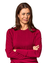 Elegant middle-aged Caucasian woman in studio setting unhappy looking in camera with sarcastic...