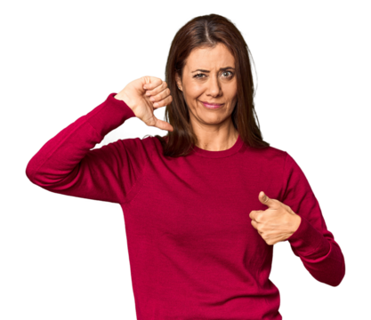 Elegant middle-aged Caucasian woman in studio setting showing thumbs up and thumbs down, difficult choose concept