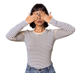 Young Hispanic woman with short black hair in studio afraid covering eyes with hands.