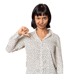 Young Hispanic woman with short black hair in studio showing thumb down, disappointment concept.