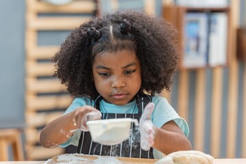 african afro black daughter kids sifting flour powder and sprinkling ingredients on massaging dough...