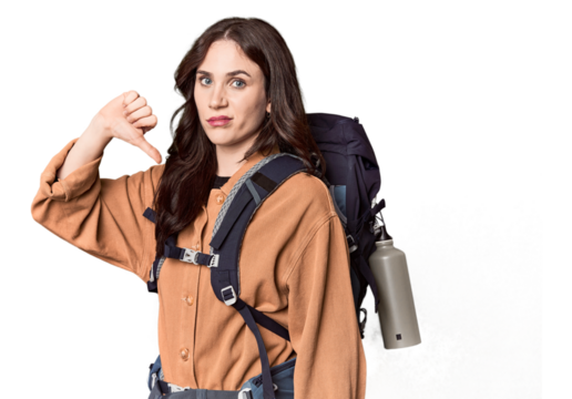 Young Caucasian with hiking gear and bottle showing a dislike gesture, thumbs down. Disagreement concept.