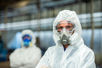 Male inspector team investigate danger chemical gas leak spill with safety face mask PPE suit in...