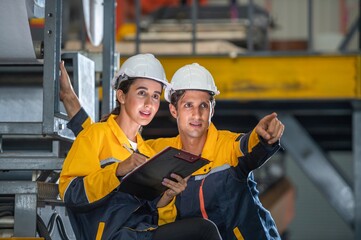 Factory apprenticeship. Man mentor teaching Female employees trainee operating machine looking...