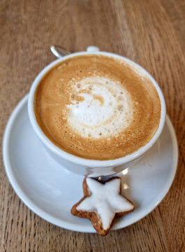 Tasse mit Cappuccino und einem Zimtstern. 