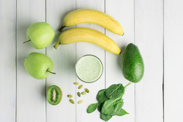 Green detox smoothie, blended vegetarian drink in a glass from spinach, apple, banana, kiwi,...