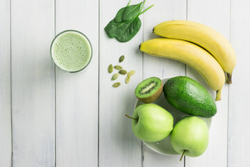 Green detox smoothie, blended vegetarian drink in a glass from spinach, apple, banana, kiwi,...
