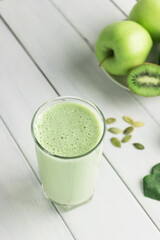 Green detox smoothie, blended vegetarian drink in a glass from spinach, apple, kiwi, avocado and...