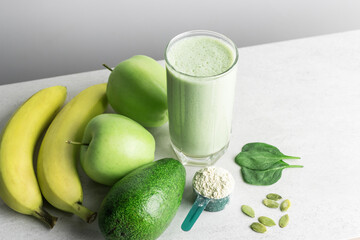 Green detox smoothie, blended vegetarian drink, protein milkshake in a glass from spinach, banana,...
