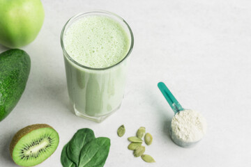 Green detox smoothie, blended vegetarian drink, protein milkshake in a glass from spinach, apple,...