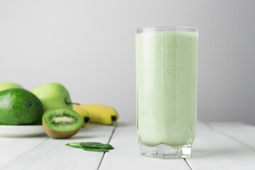 Green detox smoothie, blended vegetarian drink in a glass from spinach, apple, banana, kiwi,...