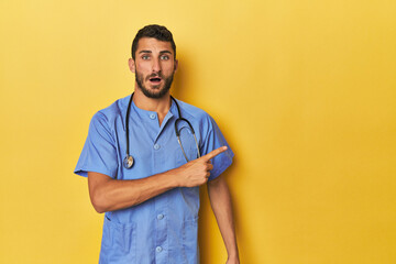 Young Hispanic male nurse Young Hispanic male nurse poses confidently pointing to the side< mixto >