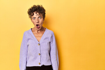 Fototapeta premium Mid-aged caucasian woman on vibrant yellow shouting very angry, rage concept, frustrated.