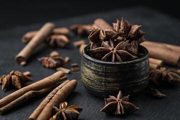 Star anise and cinnamon on a black background.