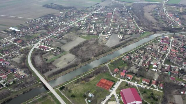 A canal DTD flows through small town Bac, Serbia, drone POV