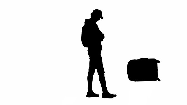 Portrait of silhouette traveler isolated on white background alpha channel. Man waiting for luggage, takes it from the carousel walks away.