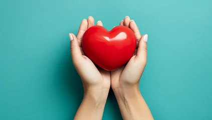 Foto op Plexiglas Hands holding red heart on isolate blue background. Health care love organ donation mindfulness wellbeing praying family insurance CSR and mental concept. World heart day and World health day © Virtual Art Studio