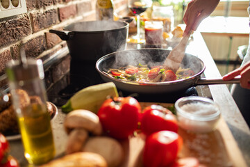 Close up woman cooking healthy pasta meal in home kitchen