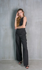 Fototapeta premium Young beautiful woman, fashion model, in a black suit in the studio