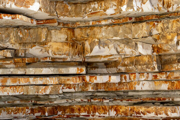 Abstract view of mountain rock layers. Layered sandstone deposits in different color abstraction. The structure of the cut of the mountain is specifically tinted in different colors.