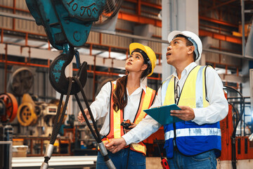 Factory foreman worker and engineer conduct inspection of industrial steel machine and metal...