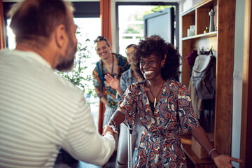 Happy young woman shaking hands with owner of rented apartment
