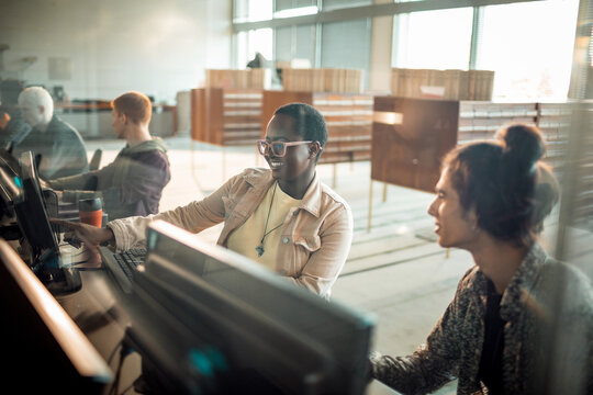 Diverse university students working on library computer