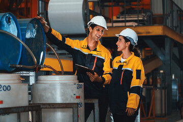 Two factory workers or engineers conduct professional inspection on machine or procedure in...