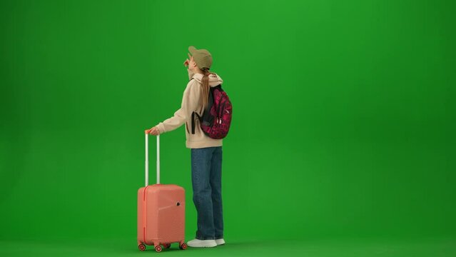 Portrait of traveler isolated on chroma key green screen background. Young girl runs to departure area late to her flight, upset expression.